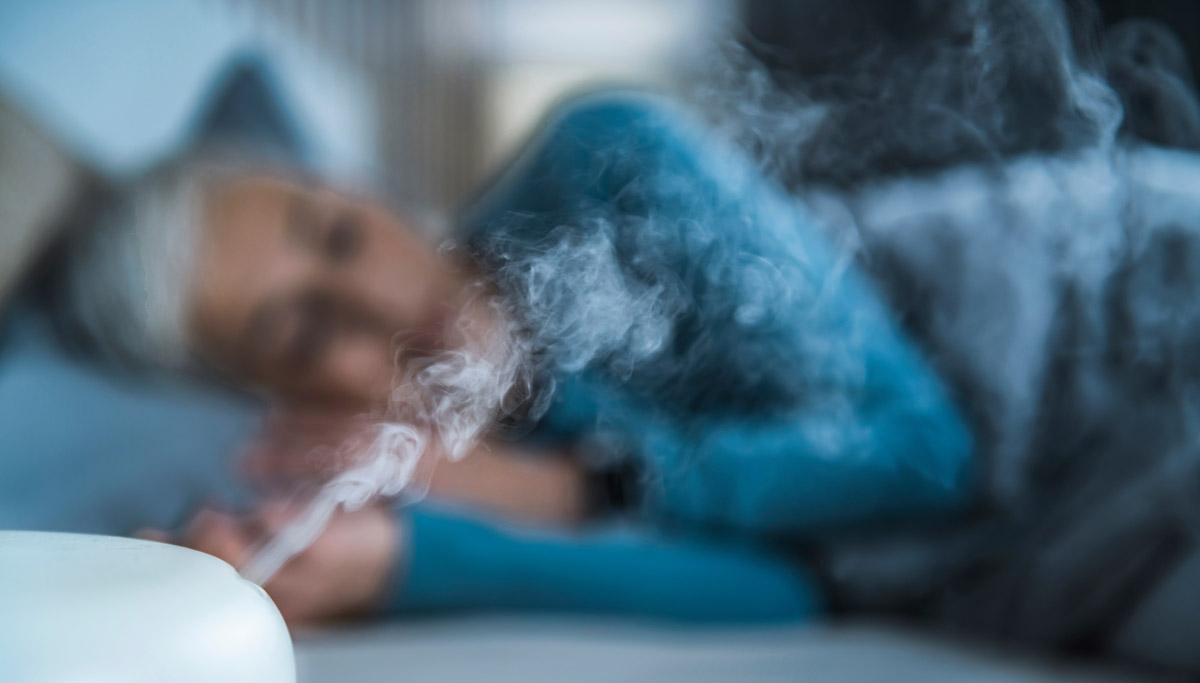 woman sleeping next to diffuser